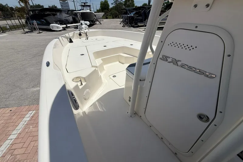 Slide: The Image of 2023 Skeeter SX2350 boat interior, showcasing deck and storage compartment in a marina setting. - 15