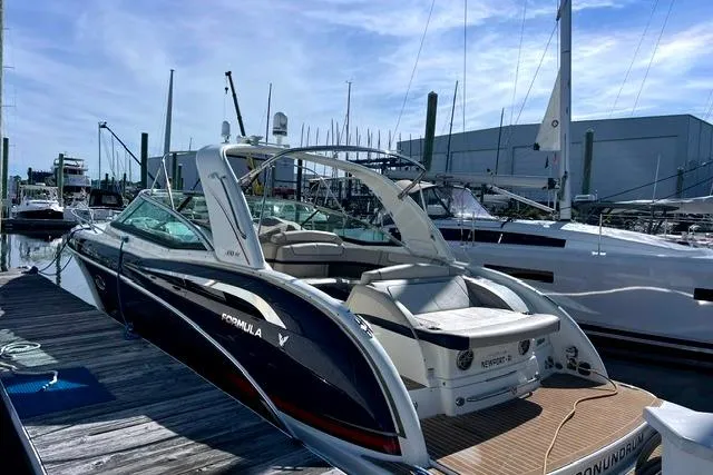 The Image of 2015 Formula 350 Sun Sport boat docked at a marina under a clear blue sky. - 2