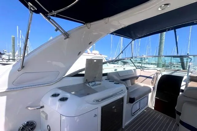 Slide: The Image of 2015 Formula 350 Sun Sport yacht interior with seating and kitchenette, docked at marina. - 9
