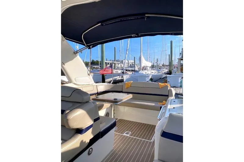 Slide: The Image of 2015 Formula 350 Sun Sport boat interior with seating and table at marina. - 11