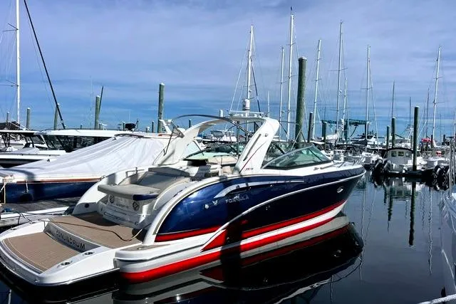 Slide: The Image of 2015 Formula 350 Sun Sport boat docked in a marina with sailboats in the background. - 15
