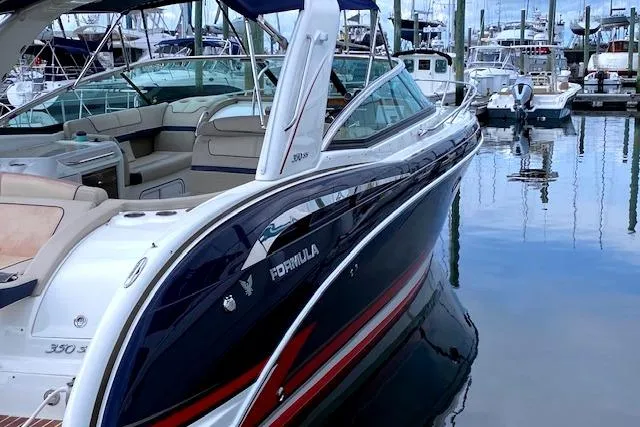 Slide: The Image of 2015 Formula 350 Sun Sport boat docked in a marina, showcasing sleek design and luxury features. - 4