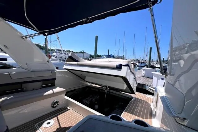 Slide: The Image of 2015 Formula 350 Sun Sport boat interior at marina, showcasing seating and open engine compartment. - 21