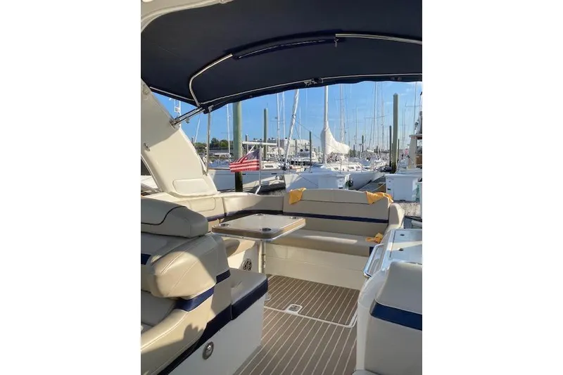 Slide: The Image of 2015 Formula 350 Sun Sport boat interior with seating and table, docked at marina. - 7