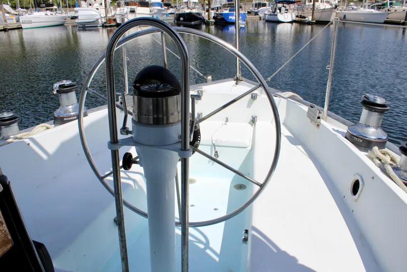 Slide: The Image of Cockpit of a 1993 Freya 39 sailboat, featuring a steering wheel and marina view. - 17
