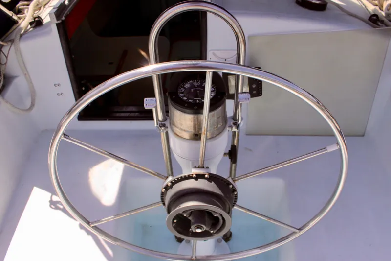Slide: The Image of Steering wheel of a 1993 Freya 39 sailboat, featuring a compass and control panel. - 19