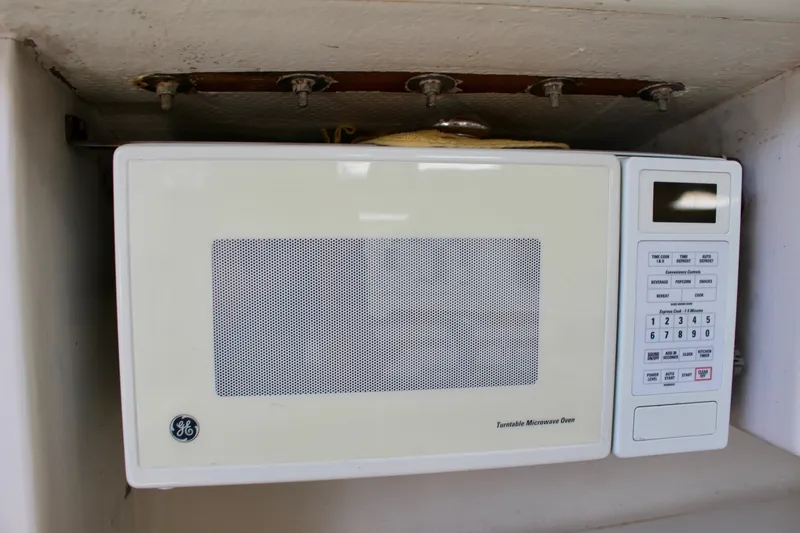 Slide: The Image of Old GE microwave oven with control panel, mounted under a shelf. - 31