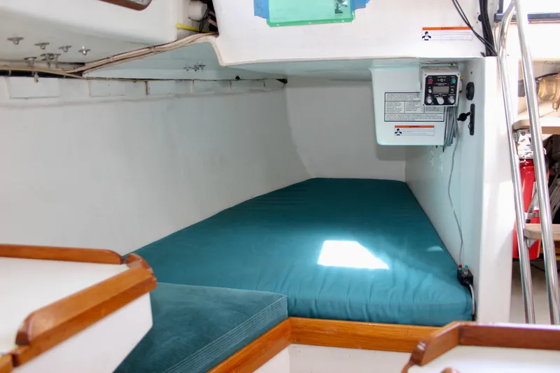 Slide: The Image of Interior cabin of 1993 Freya 39 sailboat with teal bedding and control panel. - 37