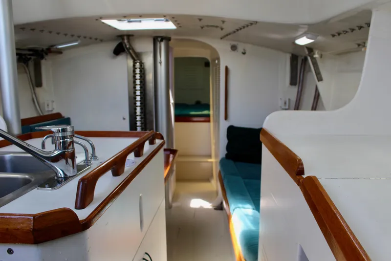 Slide: The Image of Interior of a 1993 Freya 39 sailboat, featuring a compact kitchen and cozy seating area. - 40