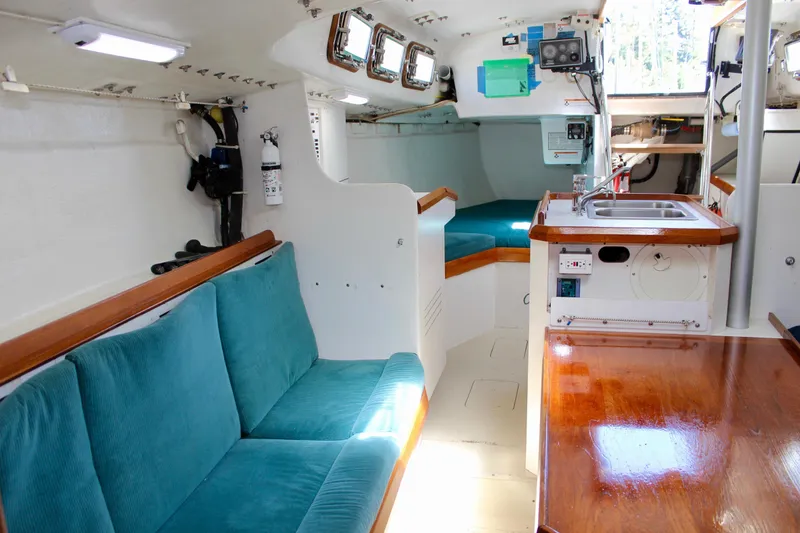 Slide: The Image of Interior of a 1993 Freya 39 sailboat with teal seating and wooden accents. - 47