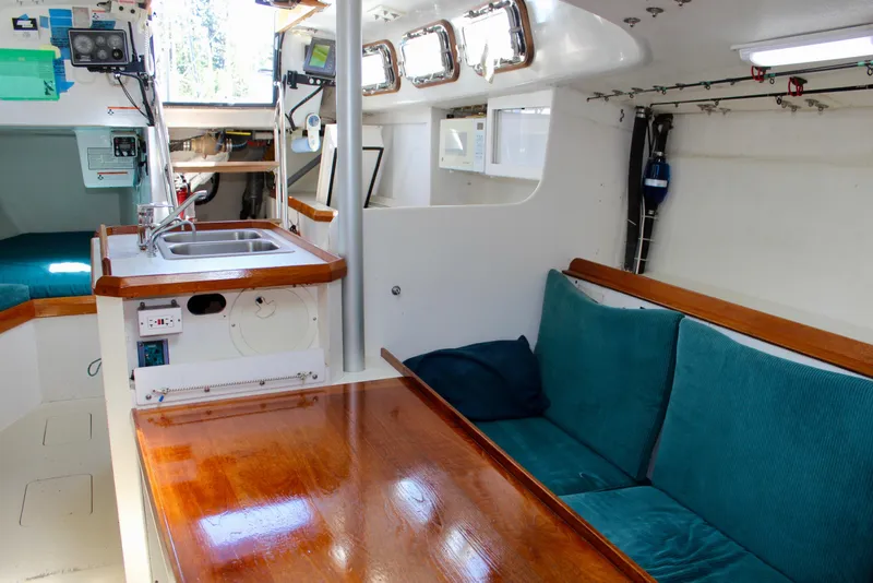 Slide: The Image of Interior of a 1993 Freya 39 sailboat with cozy seating and compact kitchen area. - 50