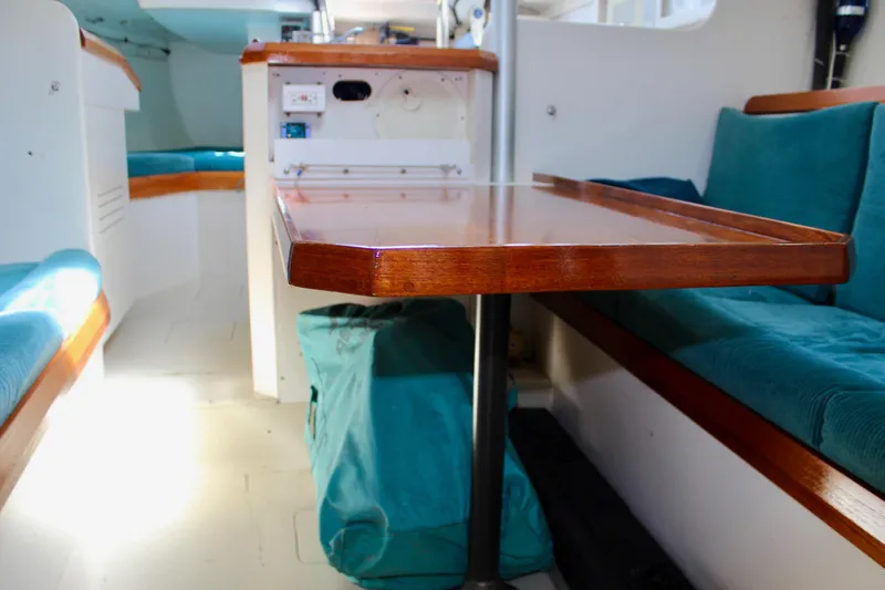 Slide: The Image of Interior of a 1993 Freya 39 sailboat with wooden table and teal seating. - 51