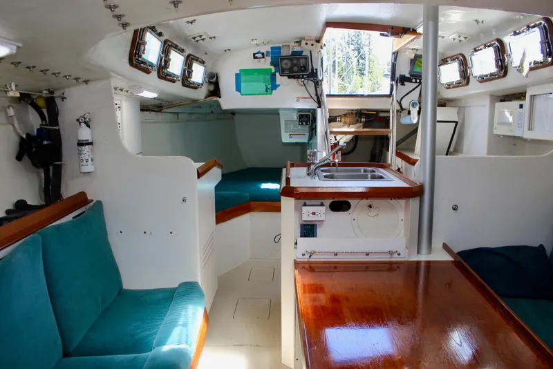 Slide: The Image of Interior of a 1993 Freya 39 sailboat with teal seating and wooden accents. - 61