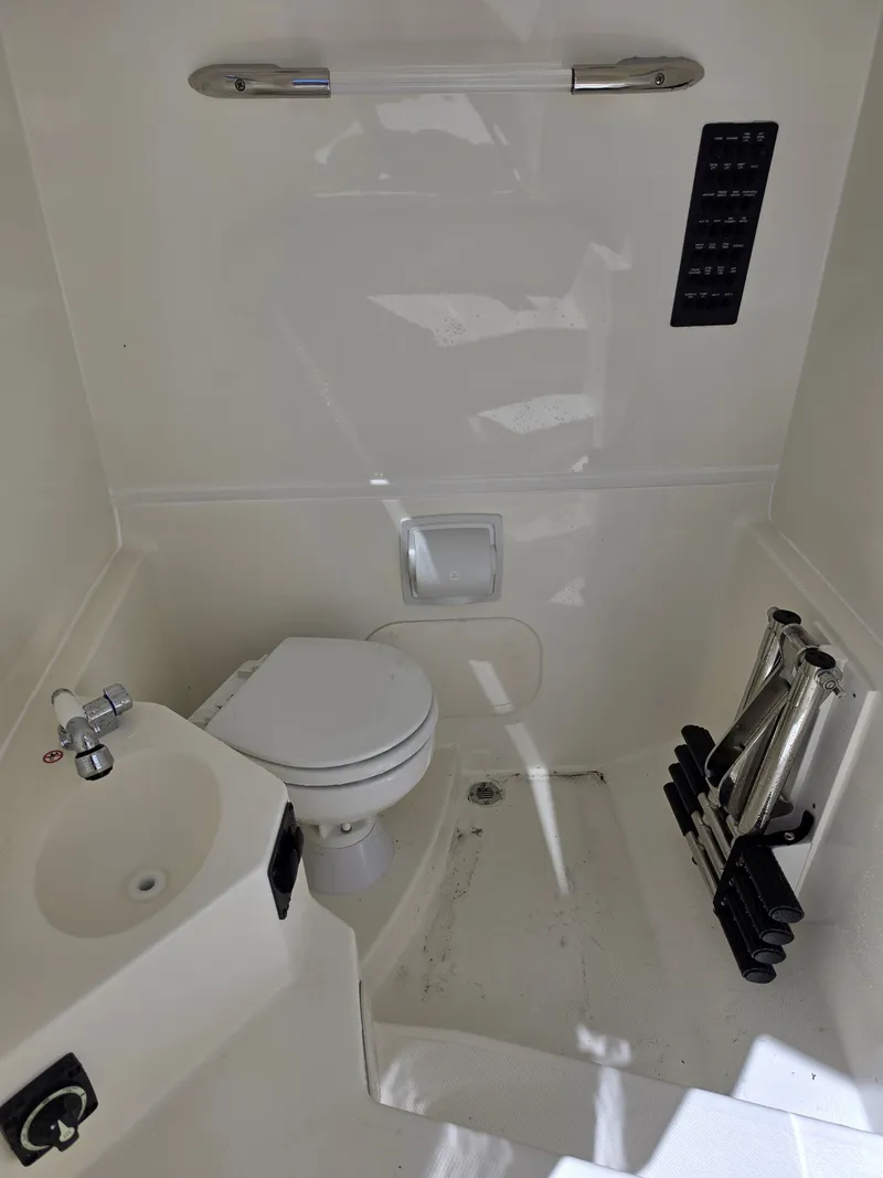 Slide: The Image of Interior of 2026 Cobia 245CC featuring toilet and sink. - 25
