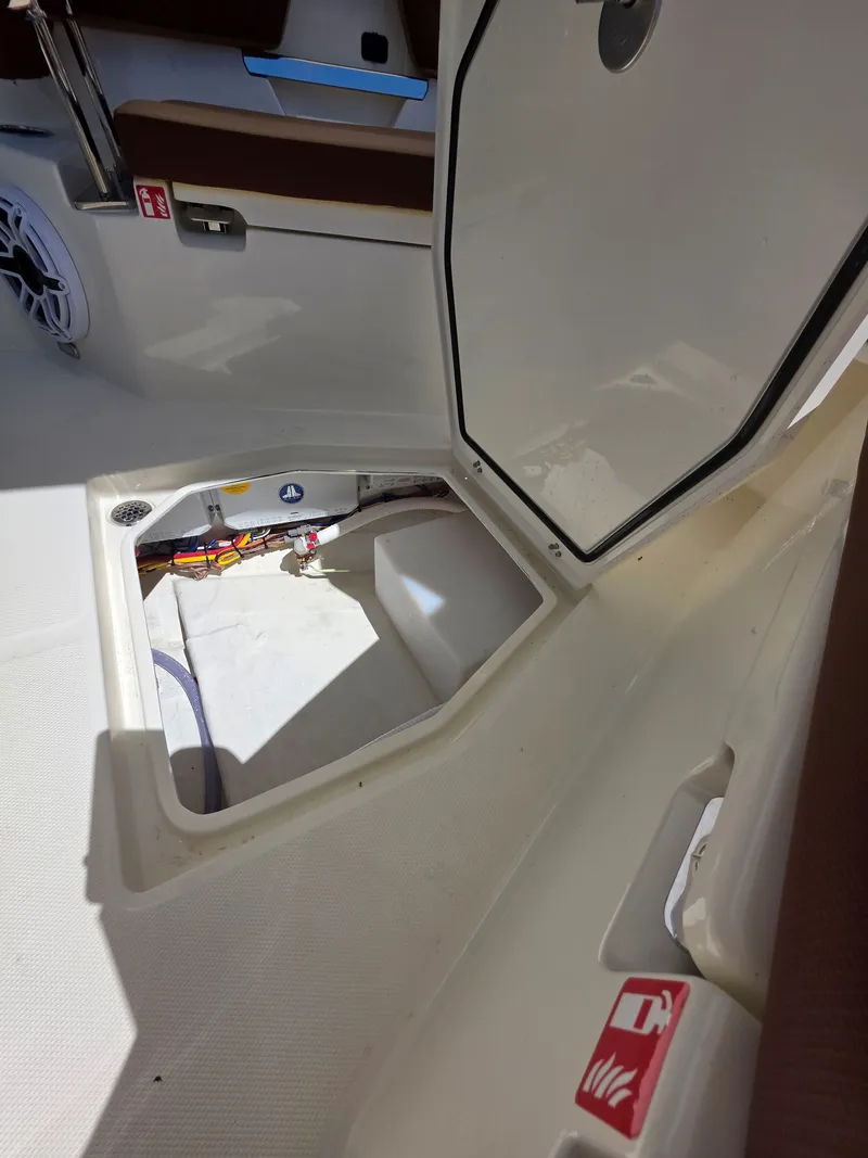 Slide: The Image of Open storage compartment in Cobia 245CC boat, model year 2026. - 26