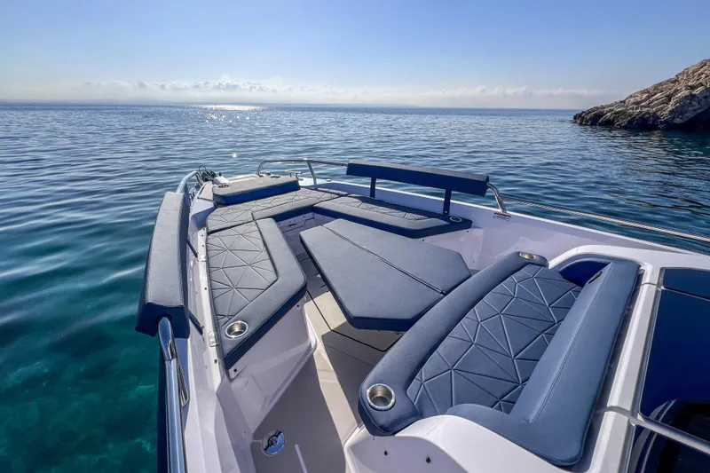 Slide: The Image of 2026 Axopar 29 XC Cross Cabin boat with luxurious seating on calm ocean waters. - 12