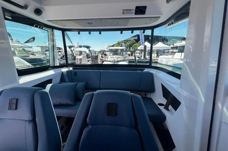 Slide: The Image of Interior of 2026 Axopar 29 XC Cross Cabin with blue seating and panoramic windows. - 15