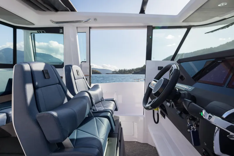 Slide: The Image of Interior view of 2026 Axopar 29 XC Cross Cabin with blue seats and steering wheel. - 3