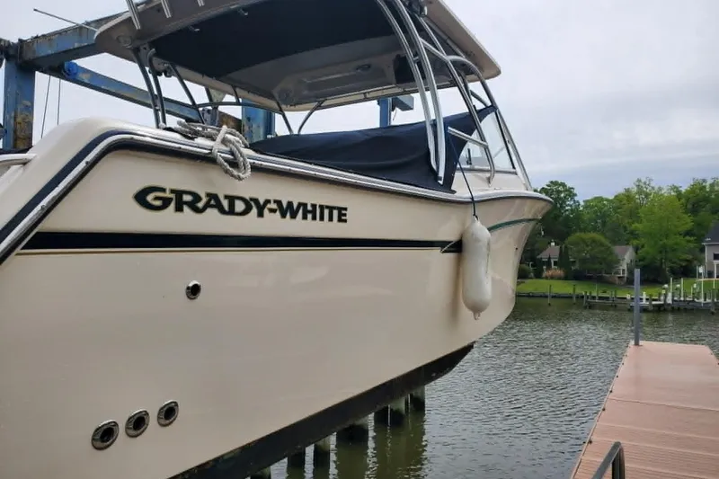 Slide: The Image of 2011 Grady-White Freedom 307 boat docked by a serene waterfront. - 3