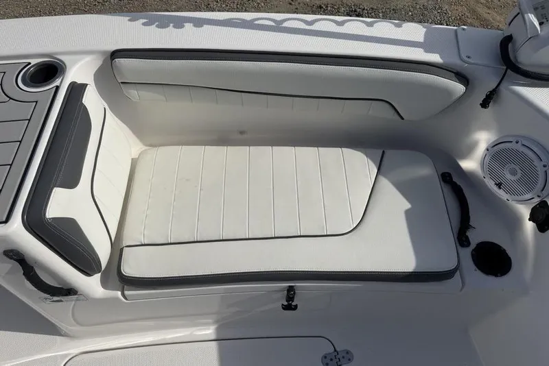 Slide: The Image of 2020 Yamaha Boats 210 FSH Sport interior seating with white upholstery and speaker. - 10
