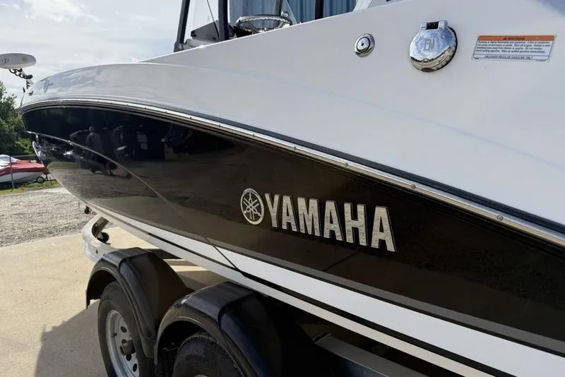 Slide: The Image of 2020 Yamaha Boats 210 FSH Sport on trailer, showcasing sleek design and branding. - 13