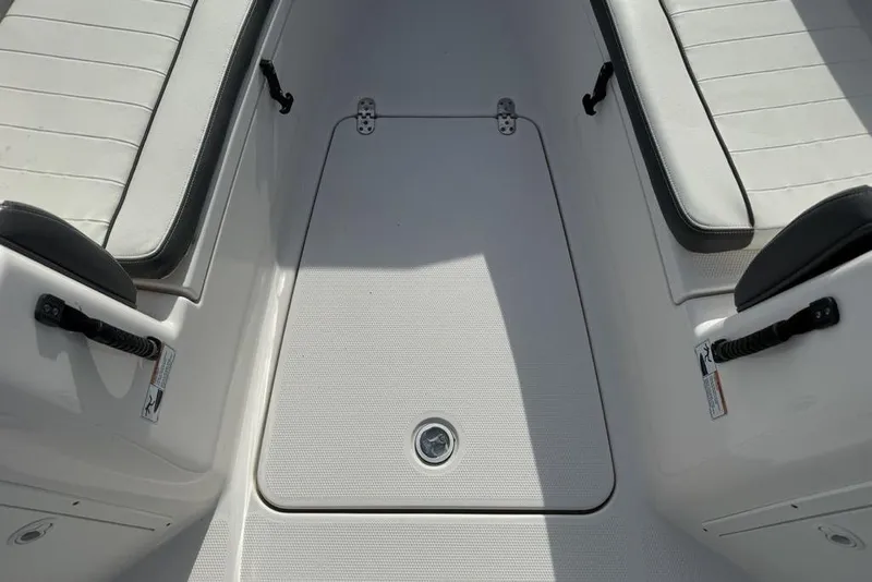 Slide: The Image of 2020 Yamaha Boats 210 FSH Sport interior with white seating and storage compartment. - 16
