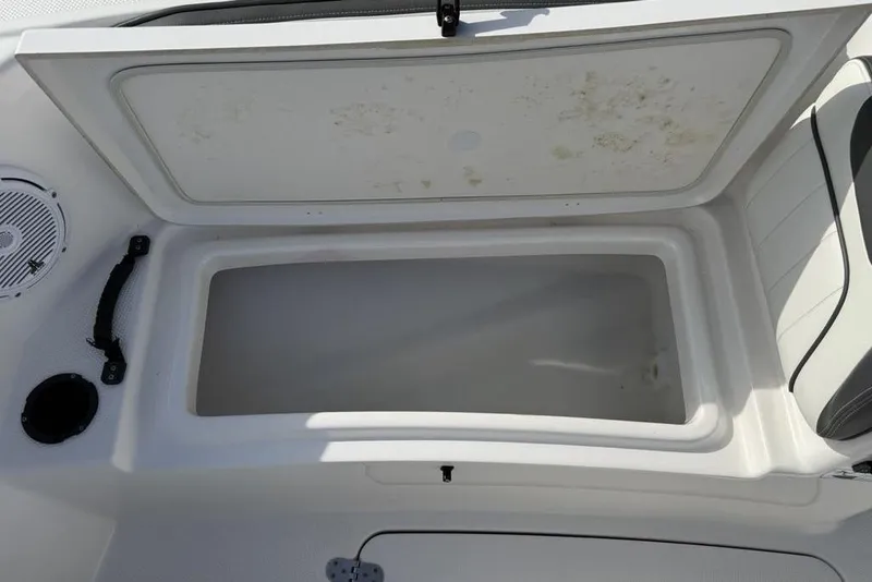 Slide: The Image of Open storage compartment on a 2020 Yamaha Boats 210 FSH Sport. - 17