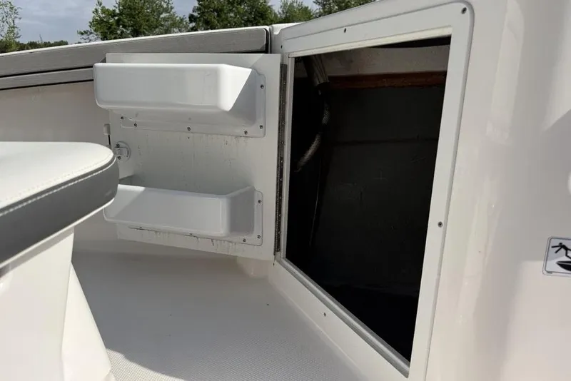 Slide: The Image of 2020 Yamaha Boats 210 FSH Sport interior storage compartment with open hatch and seating. - 21