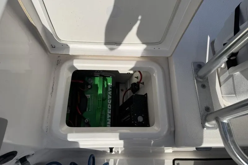 Slide: The Image of Battery compartment of a 2020 Yamaha Boats 210 FSH Sport, featuring an Interstate battery. - 28