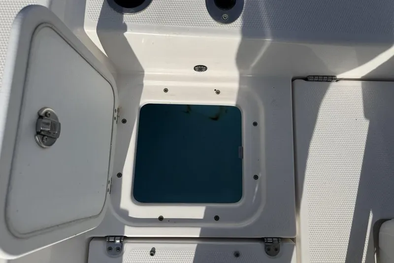 Slide: The Image of Open storage compartment on a 2020 Yamaha Boats 210 FSH Sport. - 29