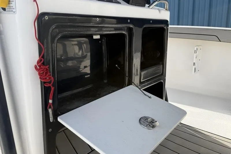 Slide: The Image of Open storage compartment on a 2020 Yamaha Boats 210 FSH Sport. - 31
