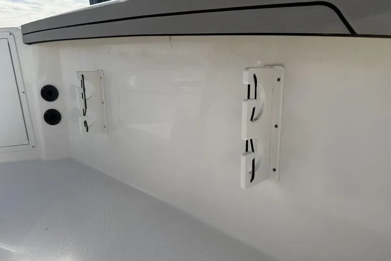 Slide: The Image of 2020 Yamaha Boats 210 FSH Sport interior detail with rod holders and storage compartments. - 34