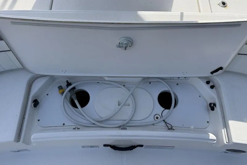 Slide: The Image of 2020 Yamaha Boats 210 FSH Sport storage compartment with hose and fittings. - 37