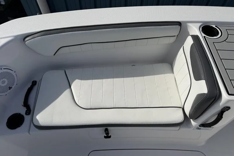 Slide: The Image of 2020 Yamaha Boats 210 FSH Sport interior seating with white upholstery and cup holder. - 6