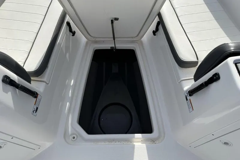Slide: The Image of 2020 Yamaha Boats 210 FSH Sport storage compartment with cushioned seating and safety handles. - 9