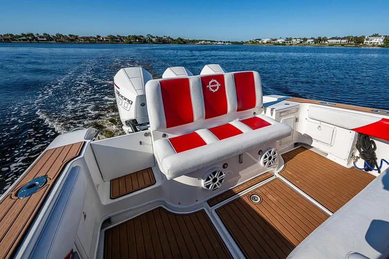 Slide: The Image of 2009 Fountain 38 Center Console boat with red and white seating, cruising on a sunny day. - 13