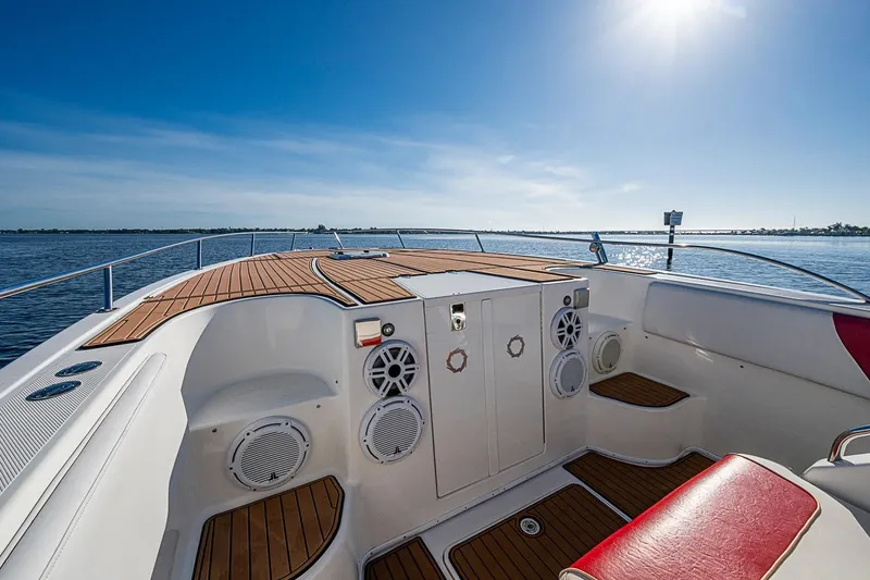 Slide: The Image of 2009 Fountain 38 Center Console boat interior with wooden deck and speakers, under clear blue sky. - 17