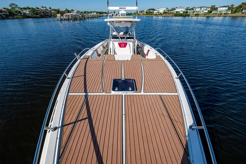 Slide: The Image of 2009 Fountain 38 Center Console boat on calm water, featuring spacious deck and sleek design. - 21