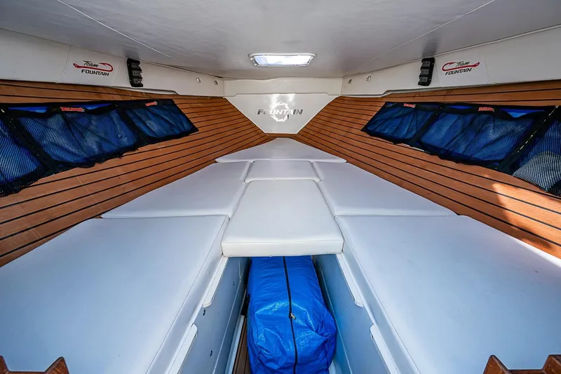 Slide: The Image of 2009 Fountain 38 Center Console cabin interior with wood paneling and cushioned seating. - 24