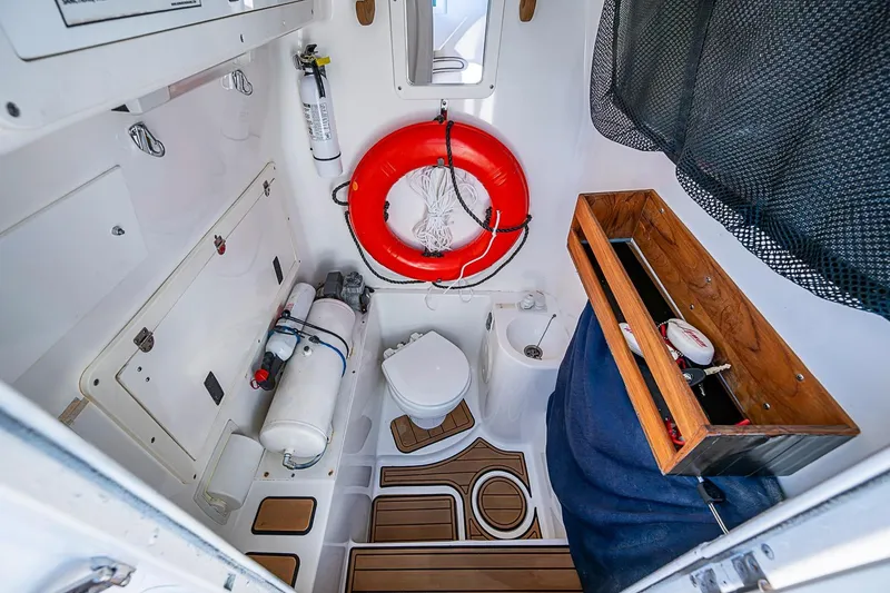 Slide: The Image of 2009 Fountain 38 Center Console boat interior with toilet, life preserver, and storage. - 26