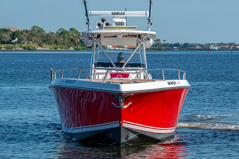 Slide: The Image of 2009 Fountain 38 Center Console boat with red hull on calm water. - 3