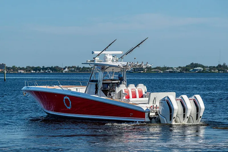 Slide: The Image of 2009 Fountain 38 Center Console boat with red hull and multiple outboard engines on water. - 35