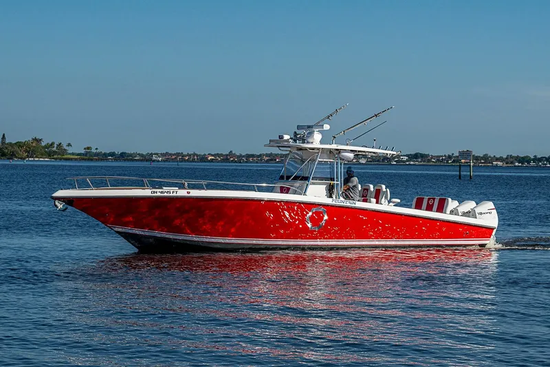 Slide: The Image of 2009 Fountain 38 Center Console boat with red hull cruising on calm water. - 36