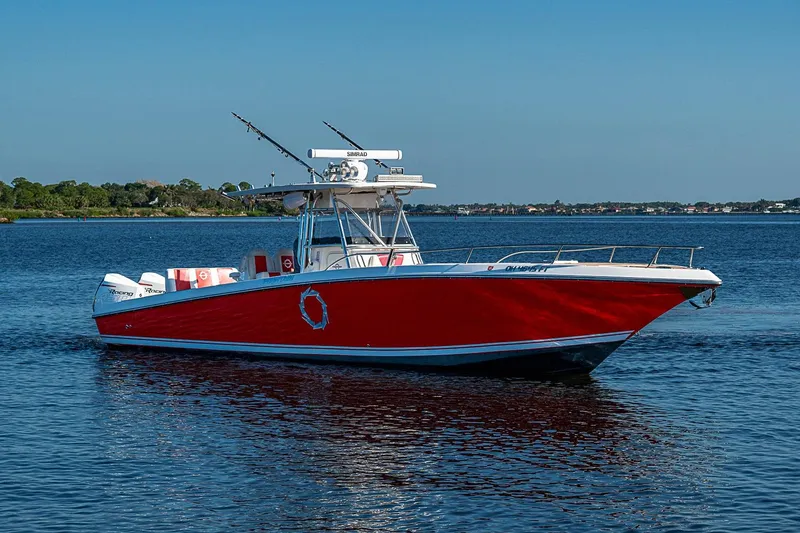 Slide: The Image of 2009 Fountain 38 Center Console boat with red hull on calm water. - 39