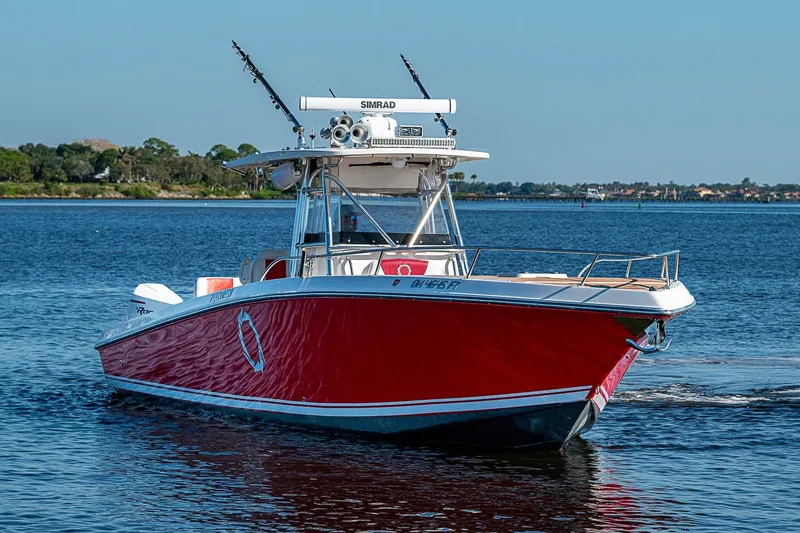 Slide: The Image of 2009 Fountain 38 Center Console boat with red hull cruising on a calm lake. - 4