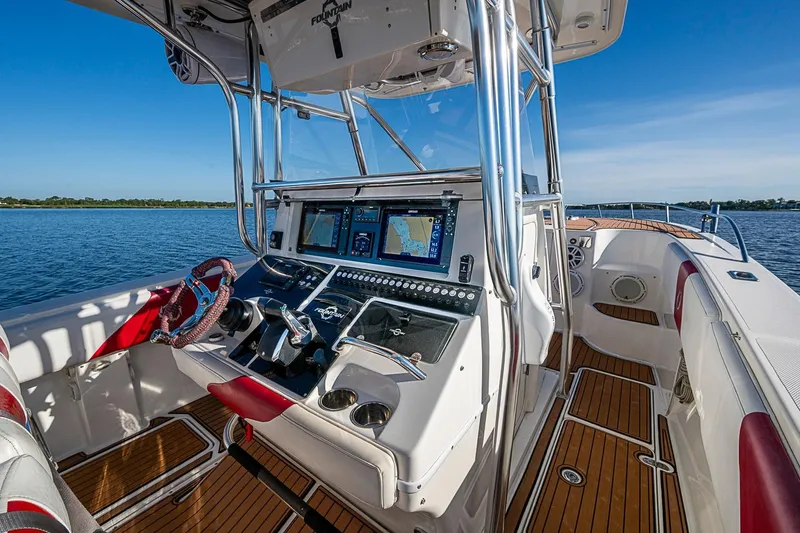 Slide: The Image of 2009 Fountain 38 Center Console boat interior with navigation screens and steering wheel. - 9