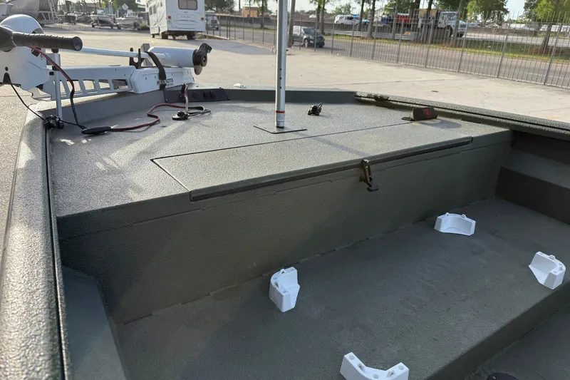Slide: The Image of 2014 Excel 203 Bay Pro boat deck with trolling motor in a parking area. - 11