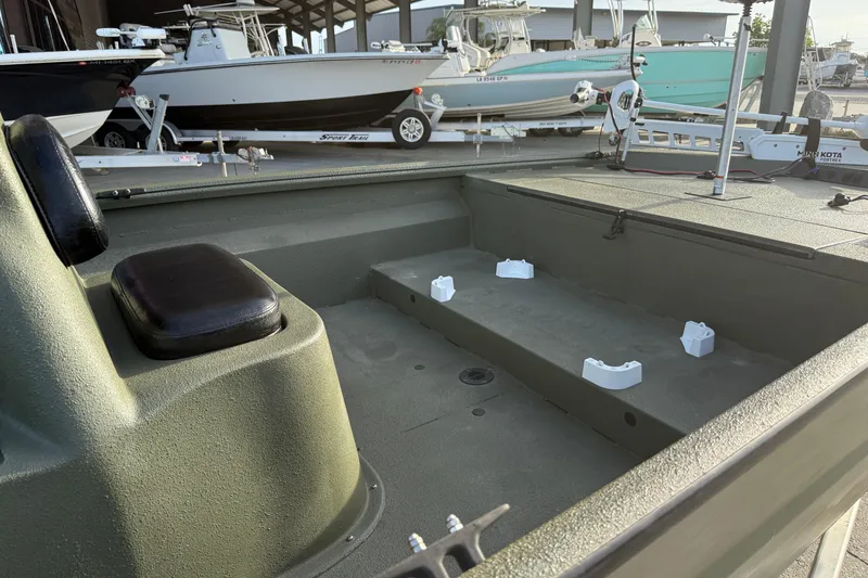 Slide: The Image of 2014 Excel 203 Bay Pro boat interior with seating and storage, docked alongside other boats. - 13