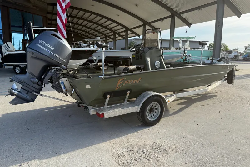Slide: The Image of 2014 Excel 203 Bay Pro boat with Yamaha outboard motor on trailer, parked under a canopy. - 3