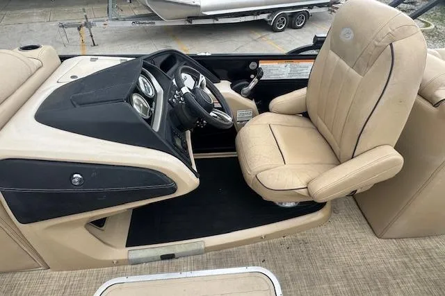 Slide: The Image of 2020 Barletta Lusso 25QCSS boat interior with beige captain's chair and sleek dashboard design. - 15